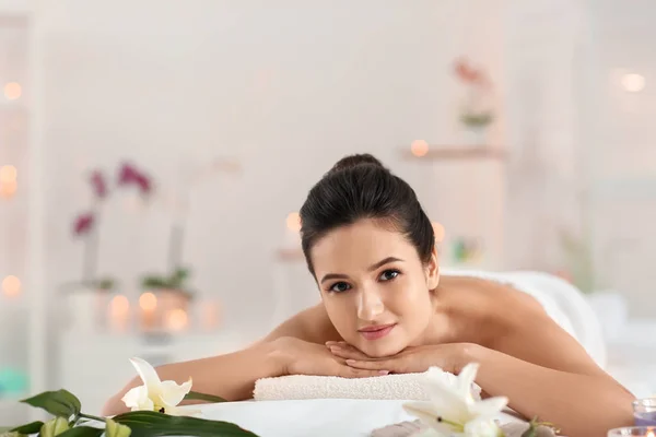 Young woman relaxing on massage table at spa salon — Stock Photo, Image