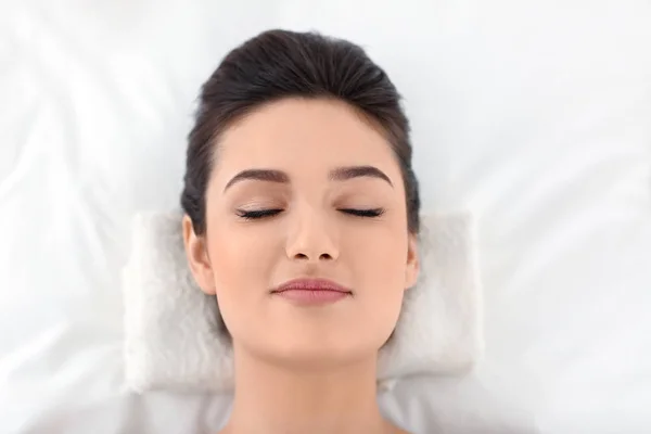 Young woman relaxing on massage table at spa salon, top view — Stock Photo, Image