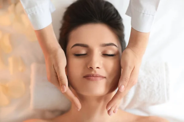 Mujer joven recibiendo masaje facial en el salón de spa, vista superior —  Fotos de Stock