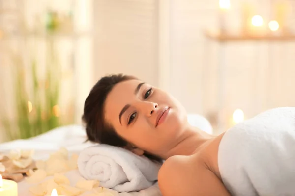 Giovane donna rilassante sul lettino da massaggio al salone spa — Foto Stock