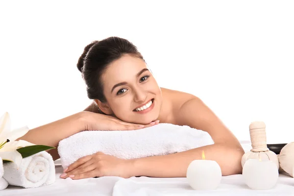 Jovem relaxante na mesa de massagem contra fundo branco. Procedimentos de spa — Fotografia de Stock