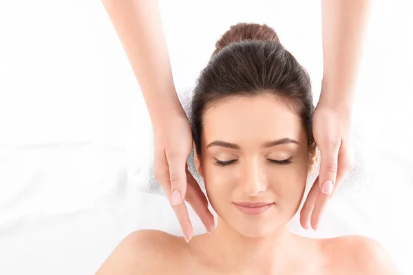 Young woman receiving face massage on white background, top view. Spa procedures