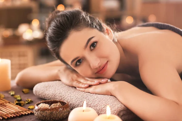 Giovane donna rilassante sul lettino da massaggio al salone spa — Foto Stock