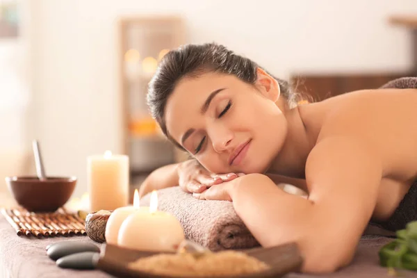 Young woman relaxing on massage table at spa salon — Stock Photo, Image