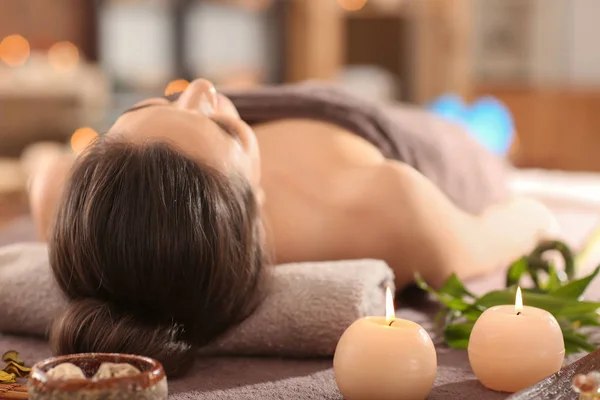 Junge Frau entspannt auf Massagetisch im Wellness-Salon — Stockfoto