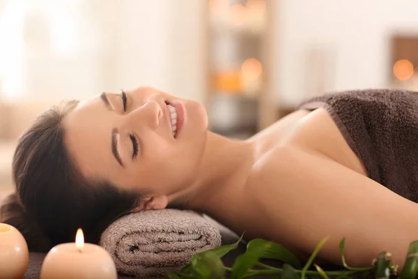 Jovem relaxante na mesa de massagem no salão de spa — Fotografia de Stock