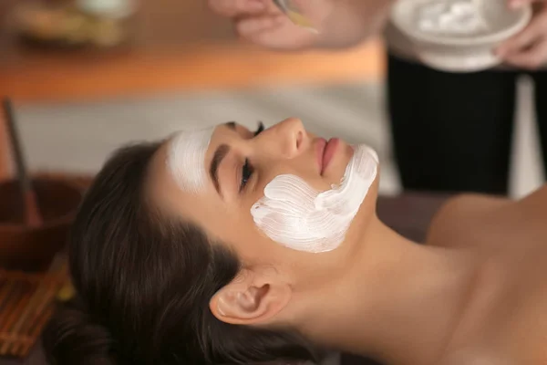 Beautician applying cosmetic mask on woman's face in spa salon — Stock Photo, Image