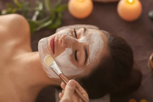 Beautician applying cosmetic mask on woman's face in spa salon — Stock Photo, Image