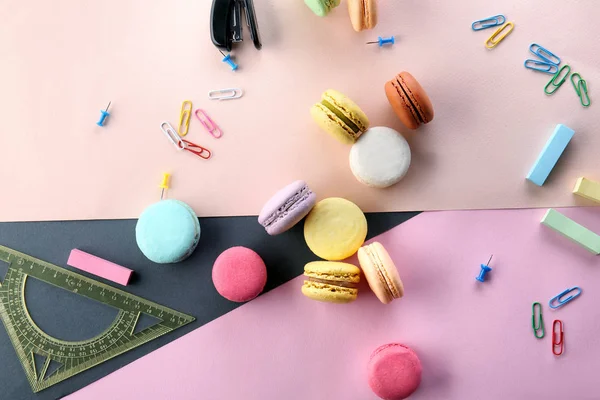 Flat lay composition with delicious macarons and stationery on color background — Stock Photo, Image