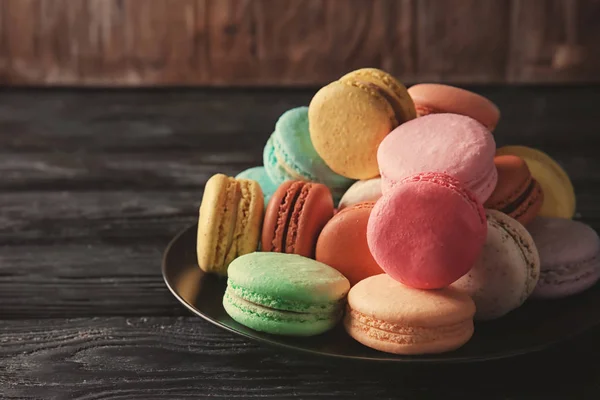 Plate with colorful macarons on table — Stock Photo, Image