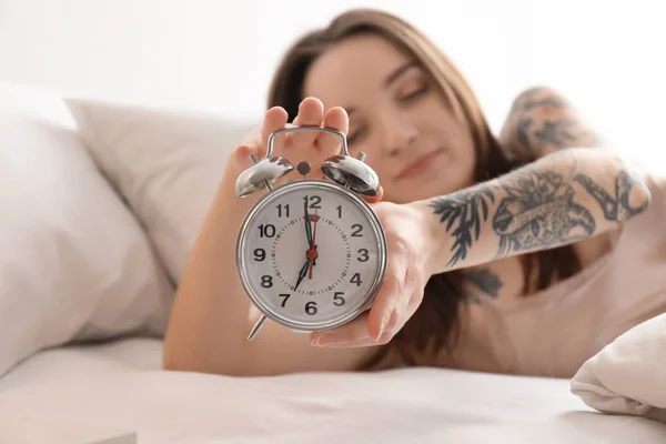 Young woman turning off alarm clock in bed. Early morning — Stock Photo, Image