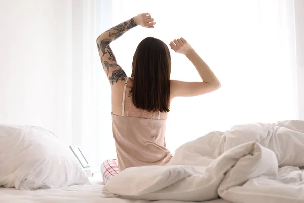 Jovem mulher bonita que se estende na cama de manhã — Fotografia de Stock