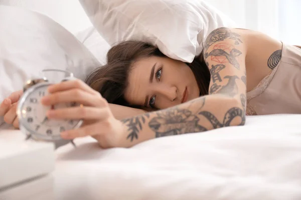 Young woman with alarm clock in bed. Early morning — Stock Photo, Image