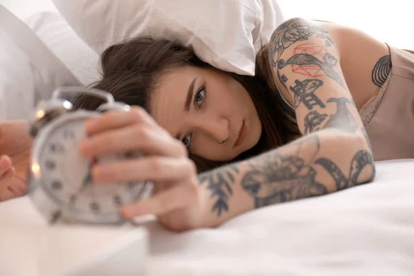 Fiatal nő az ágyban ébresztőórával. Kora reggel — Stock Fotó