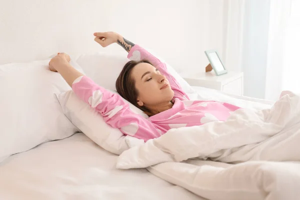 Young beautiful woman stretching on bed in morning — Stock Photo, Image