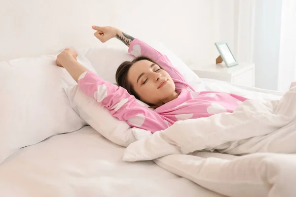 Young beautiful woman stretching on bed in morning — Stock Photo, Image