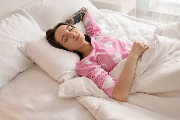 Ung vacker kvinna sover i sängen hemma. Tidigt på morgonen — Stockfoto