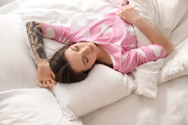 Ung vacker kvinna sover i sängen hemma. Tidigt på morgonen — Stockfoto