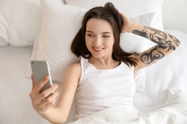 Młoda kobieta piękna, biorąc selfie na łóżko rano — Zdjęcie stockowe