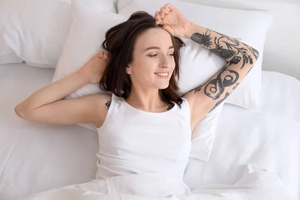 Young beautiful woman lying on bed in morning — Stock Photo, Image