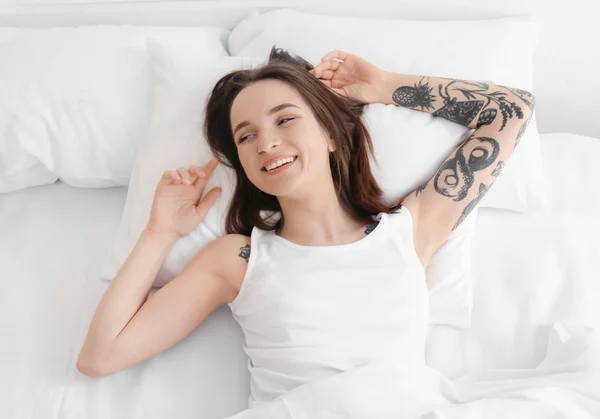 Young beautiful woman lying on bed in morning — Stock Photo, Image