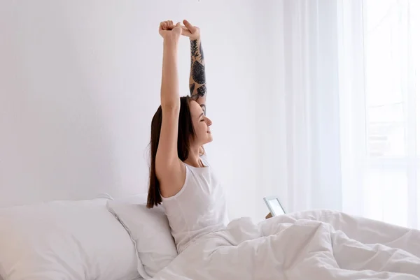 Young beautiful woman stretching on bed in morning — Stock Photo, Image