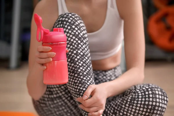 Młoda kobieta z butelka w siłowni, zbliżenie — Zdjęcie stockowe