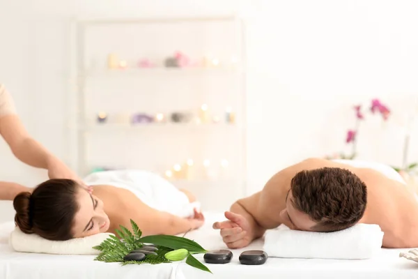 Happy young couple having massage in spa salon