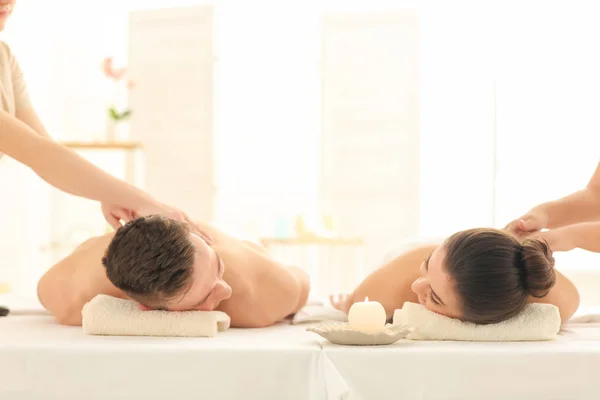 Felice giovane coppia avendo massaggio nel salone spa — Foto Stock