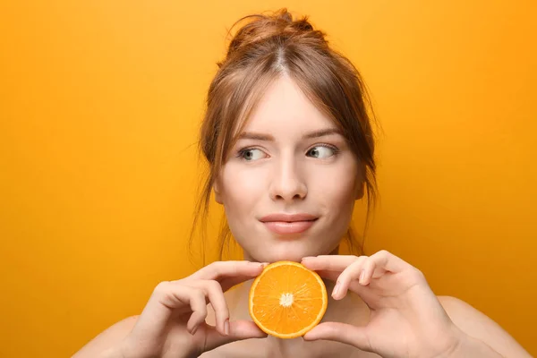 Beautiful young woman with citrus fruit on color background — Stock Photo, Image