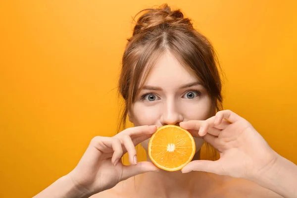 Beautiful funny young woman with citrus fruit on color background — Stock Photo, Image