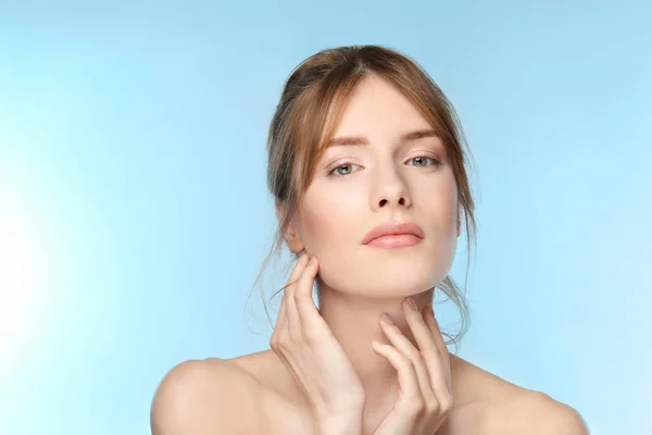 Mooie jonge vrouw met een zijdezachte huid op kleur achtergrond — Stockfoto