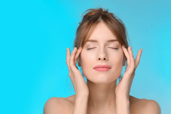 Mooie jonge vrouw met een zijdezachte huid op kleur achtergrond — Stockfoto