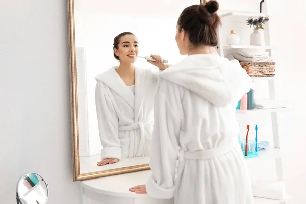 Young woman brushing teeth in morning — Stock Photo, Image