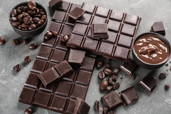 Composizione con cioccolato e chicchi di caffè su sfondo grigio — Foto Stock