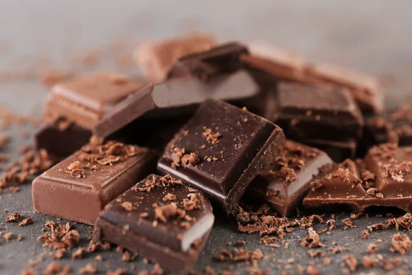 Pieces of dark and milk chocolate on table, closeup — Stock Photo, Image