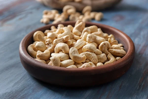 Wooden plate with tasty cashew nuts on table — Stock Photo, Image