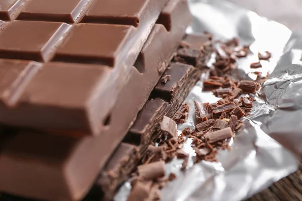 Deliciosas barras de chocolate en papel de aluminio, primer plano — Foto de Stock