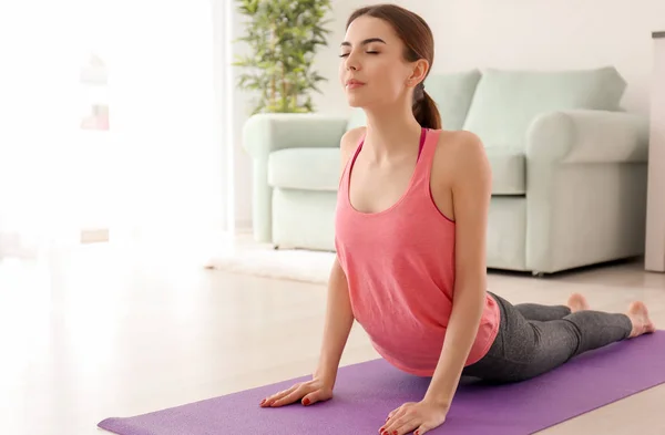 Mooie jonge vrouw die het beoefenen van yoga in ochtend — Stockfoto
