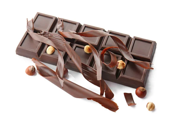 Delicious chocolate bar, shavings and hazelnuts on white background — Stock Photo, Image