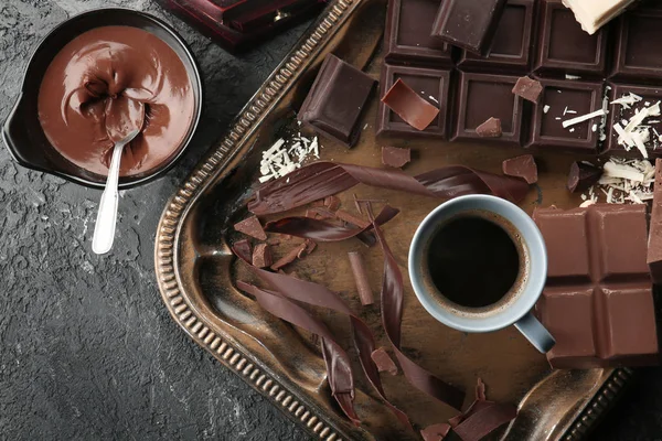 Komposisi dengan coklat lezat dan secangkir kopi di atas meja — Stok Foto