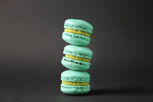 Stapel köstlicher Macarons auf dunklem Hintergrund — Stockfoto