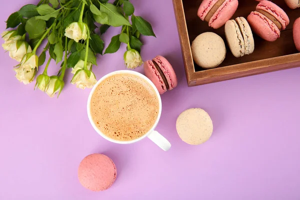 Komposition mit köstlichen Macarons, Blumen und Kaffee auf farbigem Hintergrund — Stockfoto