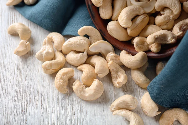 Scattered cashew nuts on white wooden table, closeup — Stock Photo, Image