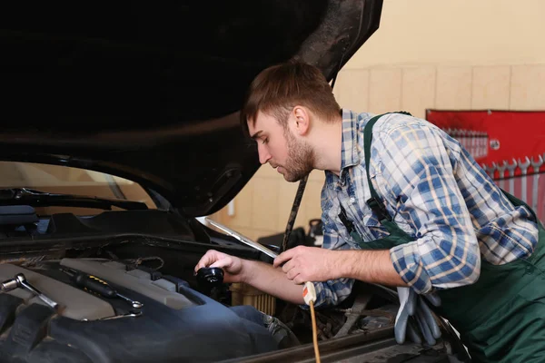 Joven mecánico de automóviles de reparación de coches en el centro de servicio — Foto de Stock