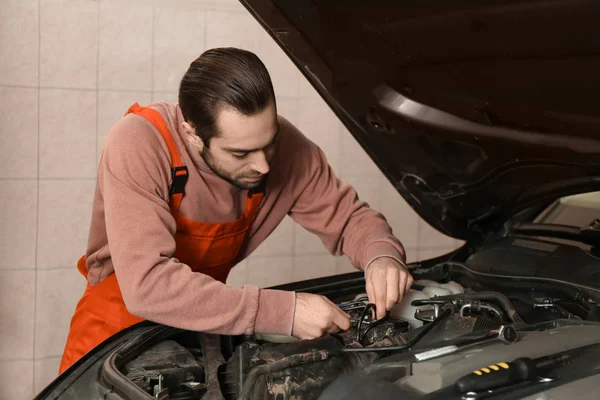 Joven mecánico de automóviles de reparación de coches en el centro de servicio — Foto de Stock