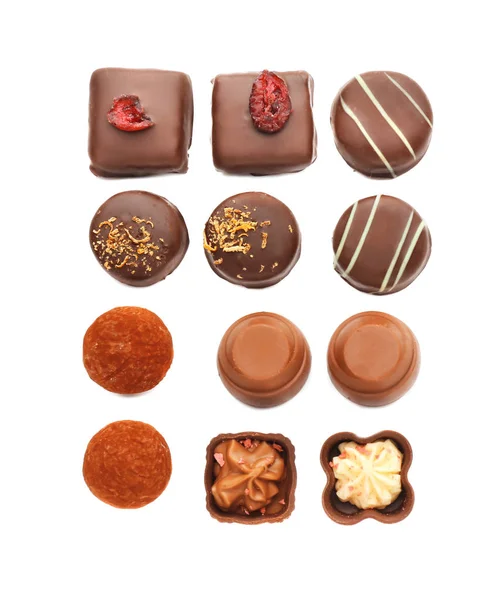 Doces de chocolate saborosos no fundo branco, flat lay — Fotografia de Stock