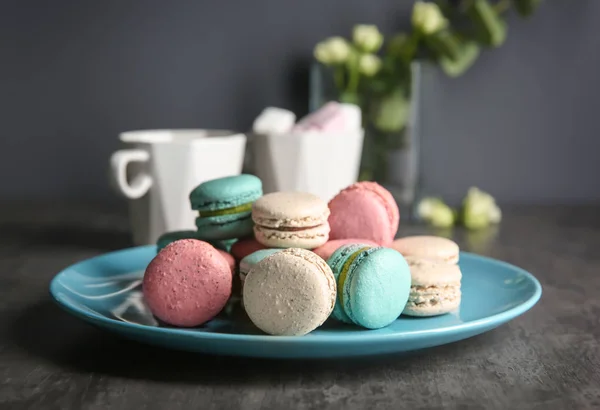 Teller mit leckeren Macarons auf dem Tisch — Stockfoto