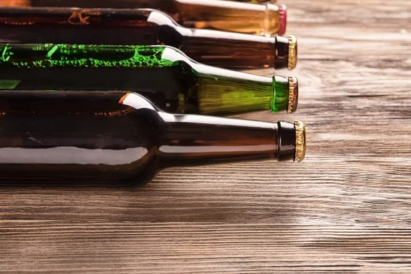 Garrafas de vidro de cerveja no fundo de madeira — Fotografia de Stock
