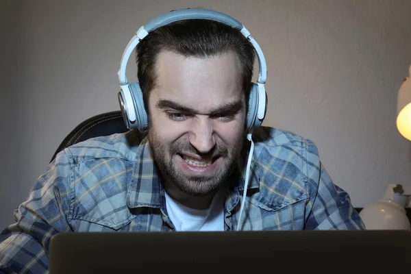 Young man playing video games on laptop at home — Stock Photo, Image